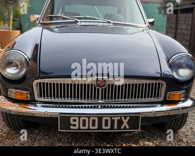 Vorderansicht des 1974 MGB GT in Mitternachtsblau mit datiertem UK-Nummernschild, das klassische britische Sportwagen und Vintage-Design unterstreicht Stockfoto