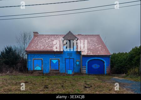 Verlassenes Haus mit blauen Straßenkunst und Wandmalereien in der Geisterstadt Doel, Belgien. Stockfoto