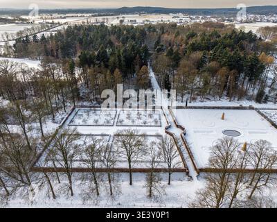 Luftaufnahme eines symmetrischen formalen, mit Schnee bedeckten Gartens. Eine majestätische Winterlandschaft mit geometrischen Hecken, gefrorenen Springbrunnen und einer dichten Kiefer Stockfoto