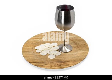 Christliche Kommunionszene mit Kelch gefüllt mit Rotwein und Waffeln auf Holzteller. Symbol der Eucharistie, des Opfers und des Glaubens isoliert auf weißem Ba Stockfoto