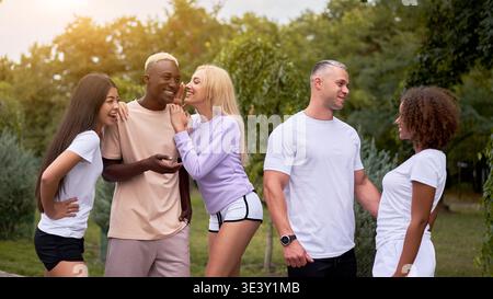 Multiethnische Gruppe Teenager Freunde. afroamerikanisch asiatisch kaukasisch Student verbringen Zeit zusammen multirassische Freundschaft glücklich lächelnde Menschen gekleidet schwarz weiß Sportbekleidung Treffen im Freien Stockfoto