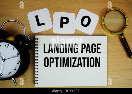 LPO Landing Page Optimization Text geschrieben auf Notizblock mit Lupe und Wecker auf hölzernem Hintergrund Stockfoto