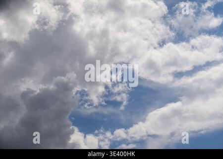 Dramatischer Himmel voller flauschiger weißer Wolken gegen leuchtendes Blau. Wolken wirken weich und strukturiert und werfen sanfte Schatten. Perfekt für Themen wie wir Stockfoto