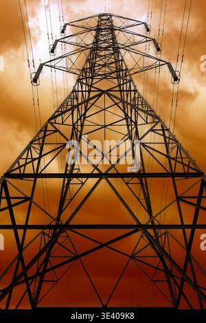 Strompylon mit Hochspannungskabel als Teil des Natioinal Grid vor Sonnenuntergang Hintergrund Stockfoto