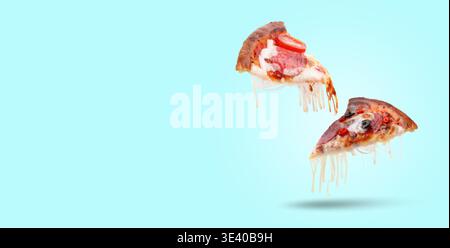 Leckere Pizzascheiben mit dehnbaren Käsesaiten in der Luft auf hellblauem Hintergrund. Bannerdesign mit Platz für Text Stockfoto