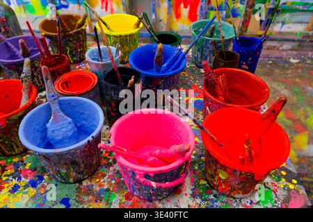 Bunte Farbeimer mit Pinseln auf einem Tisch im Zeichenstudio des Zhen Yun Lin GE Puppet Theaters. Stockfoto