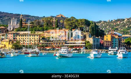 Blick auf Santa Margherita Ligure vom Meer. Traditionelle Fischerboote im Vordergrund mit farbenfrohen historischen Gebäuden und Kirchturm, Tigullio Stockfoto