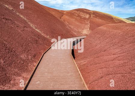 Hölzerne Promenade führt durch die pulsierenden, erodierten Hügel des Painted Cove Trail in der Wüstenlandschaft von Oregon Stockfoto