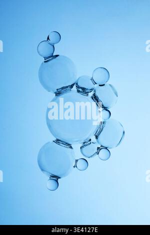 Abstraktes kosmetisches Labor. Wasserblasen, die molekulare Struktur auf blauem Hintergrund bilden Stockfoto