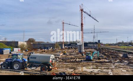 Entwicklung und Bau der Infrastruktur in Deerlijk Belgien Krane auf einer schlammigen Fläche, die das städtische Wachstum repräsentiert. Stockfoto
