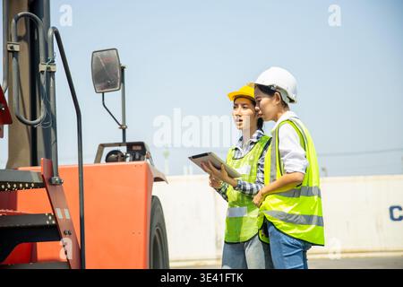 Zwei Ingenieure inspizieren Gabelstapler mit Tablet auf dem Containerhof Stockfoto