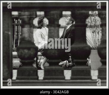Weitere Details Rizzuto, Angelo, 1906-1967, Fotograf. [Paar sitzt auf einer Bank in New York City] 09/1956 [September 1956] : das Foto zeigt einen Blick durch eine Steinschiene auf einen Mann und eine Frau, die auf einer Bank sitzen und sich gegenüberstehen. Stockfoto
