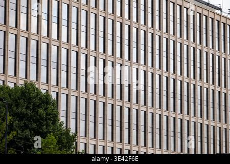 Moderne Fassade des Firmengebäudes mit sich wiederholenden Fenstern und klassischen architektonischen Elementen Stockfoto
