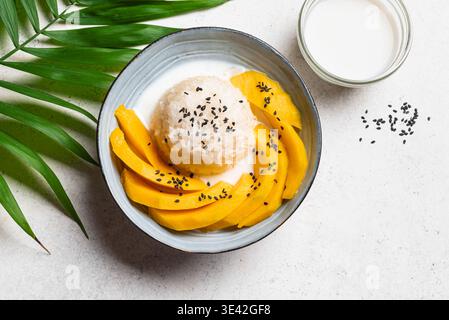 Mango Sticky Reis mit Kokosmilch und schwarzen Sesamsamen, Draufsicht, Nahaufnahme. Traditionelles thailändisches Essen. Khao niao mamuang. Stockfoto