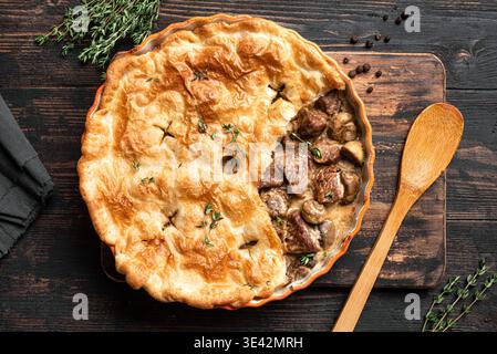 Rindfleisch und Pilzkuchen auf hölzernem Hintergrund, Blick von oben. Saisonales herzhaftes Komfortgericht - hausgemachte cremige putenfleischpastete für Thanksgiving. Stockfoto