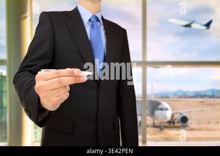 Geschäftsmann schreibt Ideen auf einem transparenten Wipeboard in der Abfluglounge am Flughafen Stockfoto