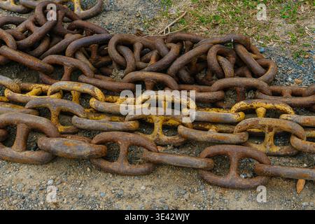 Nahaufnahme Rostfreie Kettenglieder Mit Abblätternder Gelbfarbe Und Lochmetalloberfläche, Hoher Kontrast. Stockfoto