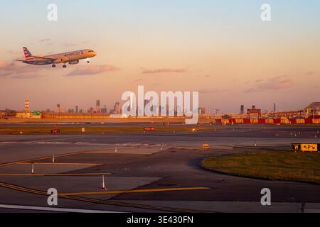 Der American Airlines Airbus A321 landet während der goldenen Stunde am Newark Liberty International Airport, New Jersey, mit der Skyline von New York in der Ferne Stockfoto