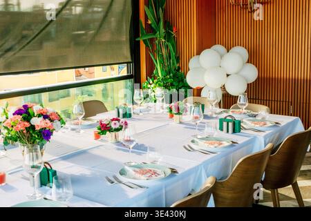 Privater Festtisch Mit Ballons, Geschenkboxen, Farbenfrohe Blumenarrangements, Weiß. Stockfoto