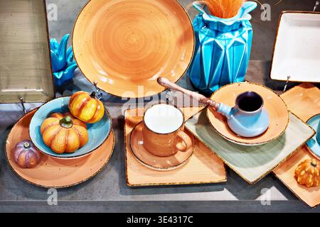 Stillleben mit Küchenutensilien, Teller, Becher, Kaffeebecher und Gemüse Stockfoto
