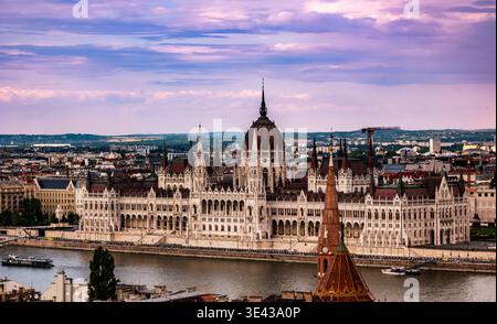 Fantastischer Abendblick auf das ungarische Parlament in Budapest durch die Bögen der Fischerbastei Stockfoto
