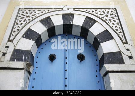Eine traditionelle Tür in einer Gasse in der Altstadt von Sidi Bou Said in der Nähe der Stadt Tunis im Norden Tunesiens in Nordafrika, Tunesien, Sidi Bou SAir, Mar Stockfoto