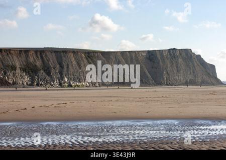 Eine ruhige und ruhige Strandszene mit beeindruckenden Klippen und einer friedlichen Gezeitenlandschaft Stockfoto