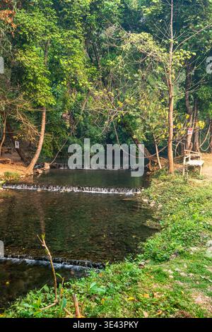 Sai Ngam Hot Springs, Pai, Thailand – 14. März 2020: Ein Waldbach fließt durch flache Pools und kleine Wehre, umgeben von Bäumen und Vegetation. Stockfoto