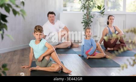 Familie mit zwei Kindern, die Yoga im Studio machen Stockfoto