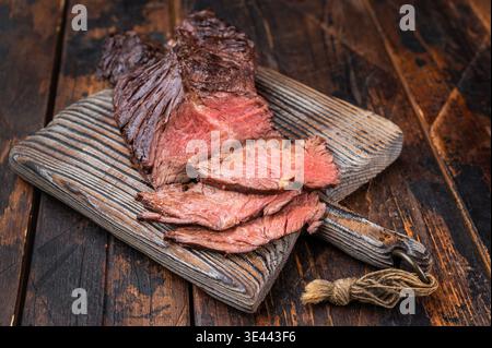 Barbecue-Stil gekochtes Rindfleischmembran Aufhänger Steak geschnitten auf Holzbrett mit Kräutern und Salz, Gabel und rustikalen Holz Hintergrund mit Kopierraum Stockfoto