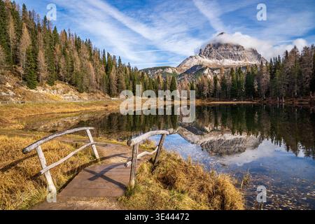 Panoramablick auf den Antornosee mit Spiegelspiegelung der Berggruppe Sorapiss und Lärchenwald im Vordergrund eine kleine Holzbrücke und gr Stockfoto