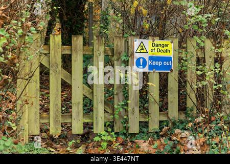 Warnschild, das die Gefahr des Todes anzeigt, und auf Holzzaun montiert fernhalten. Elektrische Gefahren und Sicherheitskonzept Stockfoto