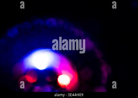 Abstrakter dunkler Hintergrund mit leuchtenden blauen, neonrosa und magentafarbenen Bokeh-Lichtern, perfekt als Überlagerung für kreative Fotoeffekte Stockfoto