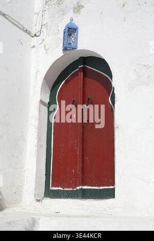 Eine traditionelle Tür in einer Gasse in der Altstadt von Sidi Bou Said in der Nähe der Stadt Tunis im Norden Tunesiens in Nordafrika, Tunesien, Sidi Bou SAir, Mar Stockfoto