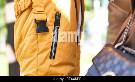 Orangefarbene Pufferjacke mit Reißverschluss, Schnalle und luxuriösem Taschendetail für ein modisches Konzept Stockfoto