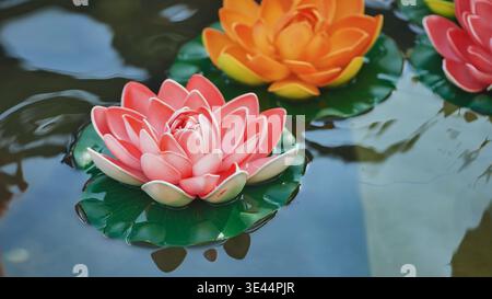 Bunte künstliche Lotusblüten, die in Vietnam auf dem Wasser schwimmen Stockfoto