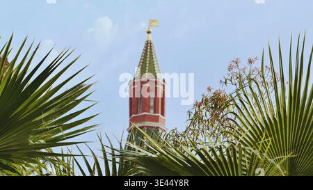 Tropische Pflanzen, die einen Kreml-Turm in Moskau umrahmen Stockfoto