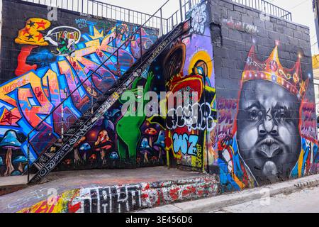 Graffiti-bedeckte Treppe in der Graffiti Alley mit lebendigen Street Art, dunklen Tönen und führenden Linien, Toronto, Kanada. Stockfoto