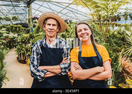 Gärtner Vater und Tochter arbeiten zusammen im Gewächshausgarten Stockfoto