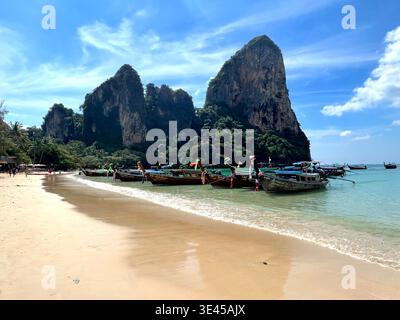 Traditionelle Longtail-Boote liegen am Railay Beach mit Kalksteinklippen Krabi Thailand vor Stockfoto