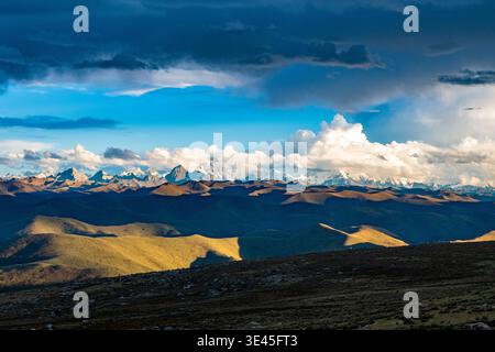 Schneebedeckte Gipfel des Mount Gongga (Minya Konka), teilweise versteckt unter dicken, rollenden Wolkenschichten in Westchina. Stockfoto