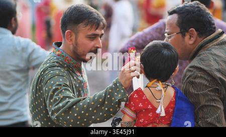 Delhi, Indien - 19. September 2025: Mann kleidet Kind in traditioneller indischer Kleidung für das Ganesh Chaturthi Festival Stockfoto