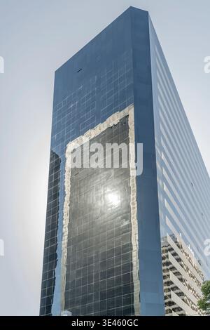 Stadtbild mit mehrfachen Sonnenspiegeln und Gebäude auf Glasfassade eines modernen Wolkenkratzers in der Nähe der avenida Leandro N. Alem in argentinischer Hauptstadt, s Stockfoto
