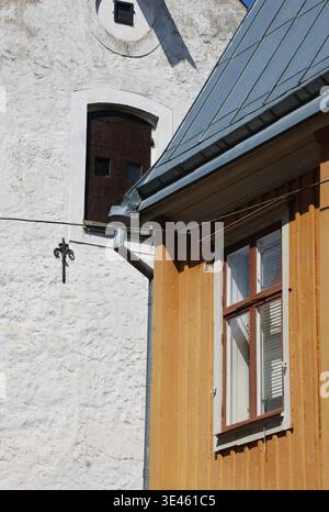 Detail der traditionellen skandinavischen Architektur mit einer hölzernen Hausfassade mit einem Fenster neben einem weißen Putzgebäude. Das Bild hebt den Text hervor Stockfoto
