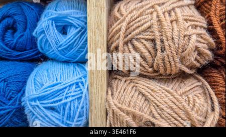 Wollgarnkugeln in Holzkiste, bunte Strickfasern angeordnet. Konzept: Gemütliches Hobby zu Hause Stockfoto
