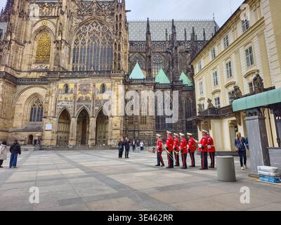 Prag, Tschechische Republik – 25. März 2026: Böhmische Burgwache in roten zeremoniellen Uniformen während des Wachwechsels auf dem Prager Burghof. Stockfoto