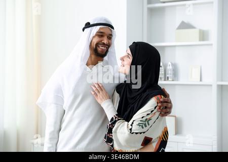 Glückliches muslimisches Paar, das sich zu Hause ansieht Stockfoto