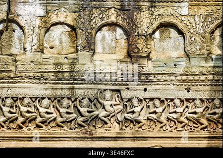 Antike Apsara-Schnitzereien zeigen himmlische Tänzer aus hinduistischen Geschichten an einer Tempelwand in Angkor, Kambodscha. Das Kunstwerk spiegelt eine reiche Kultur und Geschichte wider. Stockfoto