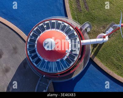 Aus der Vogelperspektive auf die bezaubernde rote und graue Struktur inmitten eines lebendigen blauen Spielplatzes und grünem Gras, Arthurstraat, Cascadepark, Flevoland, Netherla Stockfoto