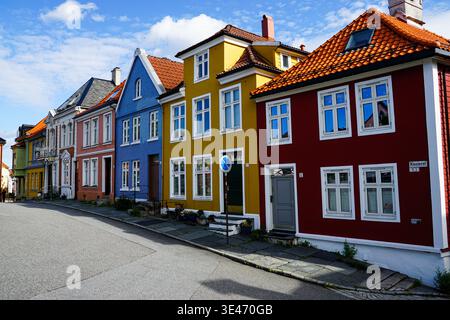 Farbenfrohe Reihe traditioneller Häuser mit Ziegeldächern entlang einer ruhigen Wohnstraße in einem europäischen Stadtviertel Stockfoto